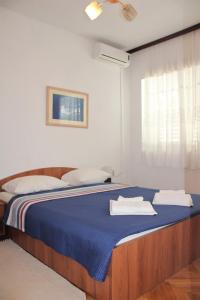 a bedroom with a blue bed with towels on it at Apartment Dora in Neum
