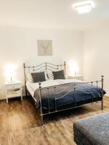 ein Schlafzimmer mit einem großen Bett und zwei Nachttischen in der Unterkunft Ferienwohnung Thiergarten in Mistelgau