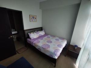 New Paradise Ocean View Apartment (DOT accredited) في بوراكاي: غرفة نوم صغيرة مع سرير مع لحاف أرجواني