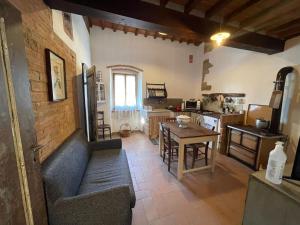 a kitchen and living room with a couch and a table at LA CORTE DEI GELSOMINI in Castiglion Fibocchi