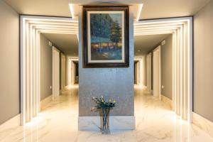 a hallway with a painting and a vase of flowers at Grand Hotel Park in Dubrovnik