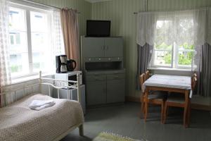 a bedroom with a bed and a table and window at Hotel Palo in Naantali