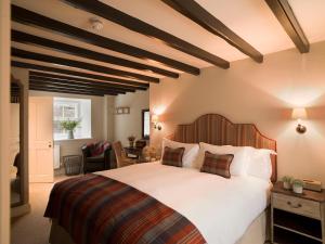 a bedroom with a large bed with a wooden headboard at Lord Crewe Arms Blanchland in Blanchland