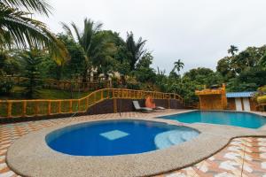 una piscina en un patio con una valla alrededor en Rainbow Forest Paradise Resort and Camping Area by Cocotel en Rizal