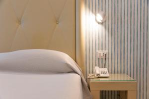 a bedroom with a bed and a phone on a table at Grand Hotel Park in Dubrovnik