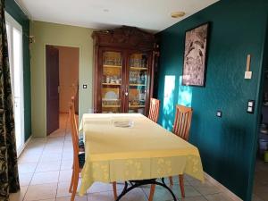comedor con mesa y mantel amarillo en Maison de 2 chambres avec jacuzzi jardin clos et wifi a Lisle sur Tarn, en Lisle-sur-Tarn