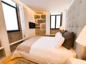 ヴィラ・ノヴァ・デ・ガイアにあるCasa dos Sequeiras Port Wine Cellarsのベッドルーム1室(大型ベッド1台、窓2つ付)
