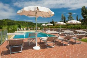 - un groupe de chaises et un parasol à côté de la piscine dans l'établissement Villa Dimora San Jacopo, à Palaia