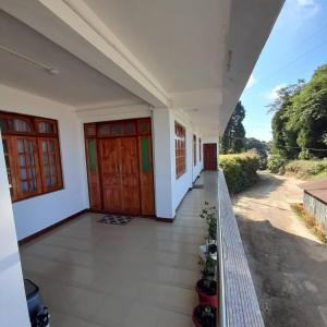 a view from the balcony of a house with two doors at Jasmine Homestay Darjeeling in Darjeeling