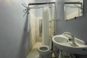 y baño con lavabo, aseo y ducha. en Mbah Mek Trawangan Homestay, en Gili Trawangan