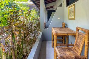 una mesa y sillas en el porche de una casa en Mbah Mek Trawangan Homestay, en Gili Trawangan