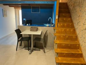 cocina con mesa, sillas y fregadero en Profumo D'arancio B&B a Pedalino en Casa Criscione