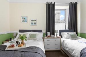 a bedroom with two beds and a table with food on it at Wayfarer Guest House in Torquay