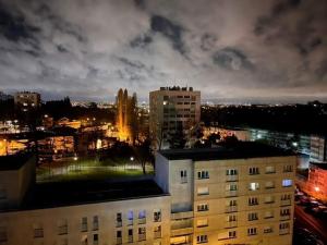 a view of a city at night with a building at 2 Superbes chambres d hôte dans un appartement avec magnifique vue sur Paris in Sucy-en-Brie