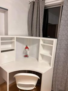 a white desk with a lamp in a room at 2 Superbes chambres d hôte dans un appartement avec magnifique vue sur Paris in Sucy-en-Brie