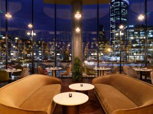 a restaurant with tables and chairs and a view of the city at Crowne Plaza - Warsaw - The HUB, an IHG Hotel in Warsaw