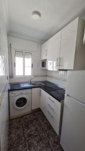 a kitchen with white cabinets and a washing machine at Apartamento Lo Pagan in Lo Pagán