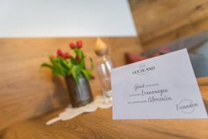 ein Schild auf einem Tisch mit einer Blumenvase in der Unterkunft Aparthotel Hochland GmbH in Nauders