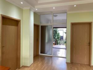 an empty room with two doors and a hallway at Huge Apartment with a Garden in the City Center in Pristina