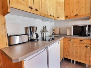 eine Küche mit Holzschränken und einer Arbeitsplatte in der Unterkunft Appartement Méribel, 2 pièces, 4 personnes - FR-1-182-51 in Méribel