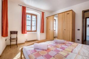 sypialnia z dużym łóżkiem i krzesłem w obiekcie Residence Lena App 4 w mieście Tenno