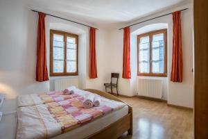 sypialnia z łóżkiem i 2 oknami z czerwonymi zasłonami w obiekcie Residence Lena App 4 w mieście Tenno