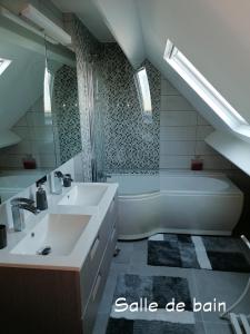 een badkamer met een bad, een wastafel en een bad bij Le Cerisier in Bioul