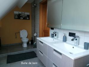 een badkamer met een witte wastafel en een toilet bij Le Cerisier in Bioul
