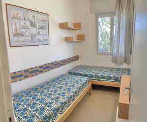 a room with two beds and a window at Residence Capobianco in Portoferraio