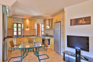 a kitchen with a table and a tv in it at Çınarlar Apart KC Blok in Kaş