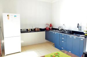 a kitchen with blue cabinets and a white refrigerator at Villa Atalaia in Aracaju