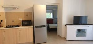a room with a kitchen with a microwave and a television at Bas de maison de village cosy & relax in Vero