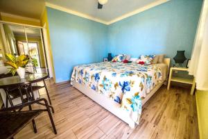 Un dormitorio con una cama con paredes azules y una mesa. en Casa Azul Las Galeras, en Las Galeras