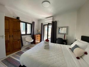 um quarto com uma grande cama branca e uma secretária em Refúgio da Vila - Refuge of the Village em Vouzela