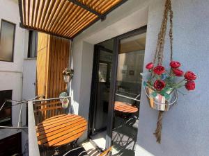 un porche con 2 sillas y un jarrón de rosas en Refúgio da Vila - Refuge of the Village, en Vouzela