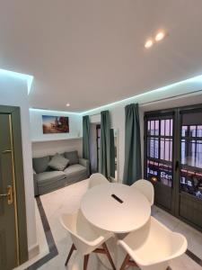 Una sala de estar con una mesa y sillas blancas. en DreamsApt Sierpes, en Sevilla