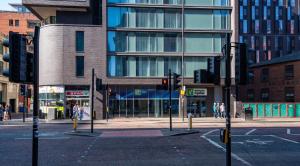 eine leere Stadtstraße mit Ampeln und Gebäuden in der Unterkunft Holiday Inn Express Manchester City Centre, an IHG Hotel in Manchester