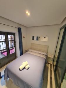 Un dormitorio con una cama con dos toallas encima. en DreamsApt Sierpes, en Sevilla