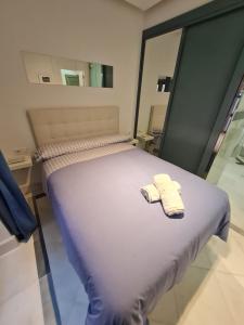 Una cama en una habitación con dos toallas encima. en DreamsApt Sierpes, en Sevilla