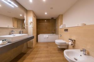 a bathroom with a sink and a toilet and a tub at Grand Hotel Park in Dubrovnik