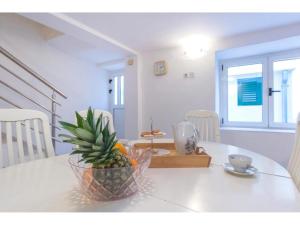 a table with a pineapple in a bowl on it at Apartment Primosten Center in Primošten