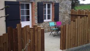 una valla frente a una casa con mesa y sillas en Gîte avec piscine ,près de Chantonnay, en Saint-Germain-de-Prinçay