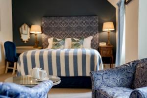 a hotel room with a bed and a table and chairs at The Swan Hotel in Bibury