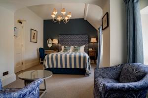 a bedroom with a bed and a table and chairs at The Swan Hotel in Bibury