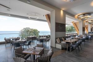 GRIFID Vistamar Hotel - 24 Hours Ultra All inclusive & Private Beach في غولدن ساندز: مطعم به طاولات وكراسي ومطل على المحيط
