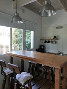 Una cocina con una gran mesa y sillas de madera. en Casa de Moras, en Tandil 20 fotos más