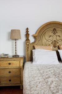 a bedroom with a bed with a lamp and a dresser at Suites of the Gods Cave Spa Hotel in Megalokhori