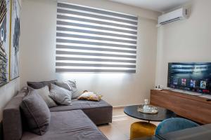 sala de estar con sofá y TV de pantalla plana en Luxury Apartment Marine View, en Agios Nikolaos