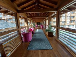een leeg balkon met roze stoelen en een tapijt bij Airy Studio Pirin Golf Aparthotel & Spa H2A92 in Razlog