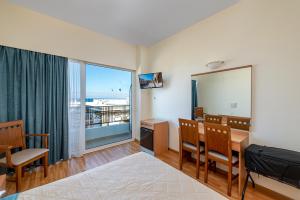 a room with a table and chairs and a mirror at Hotel Hermes in Rhodes Town